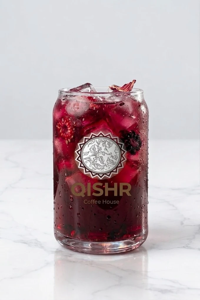 Iced hibiscus berry refresher in a Qishr-branded glass